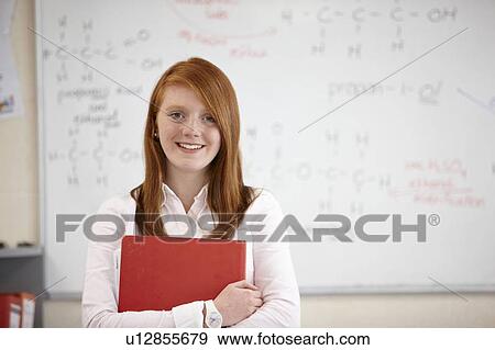 Student holding book in classroom View Large Photo Image Stock Photo - Student holding book in classroom. Fotosearch
