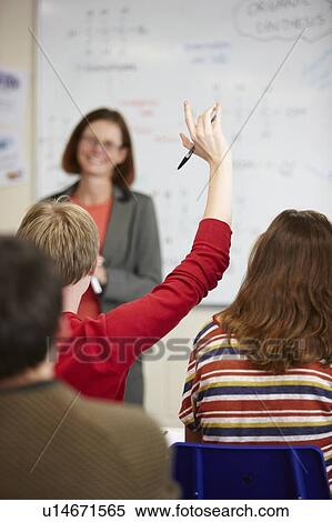 Stock Photography - Student raising hand in classroom. Fotosearch