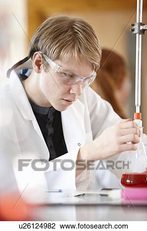 Stock Image - Student working in chemistry lab. Fotosearch