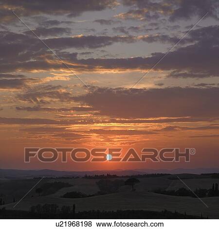 Stock Photo - Sun setting over rural landscape. Fotosearch
