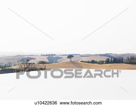 Stock Photograph - Table and chairs overlooking fields. Fotosearch
