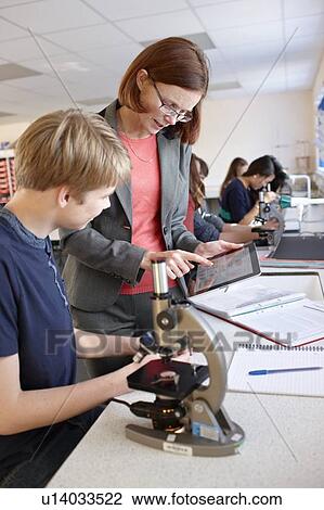 Teacher with student in science class View Large Photo Image Stock Image - Teacher with student in science class. Fotosearch
