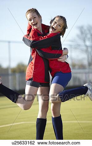 Team members hugging on field View Large Photo Image Stock Image - Team members hugging on field. Fotosearch
