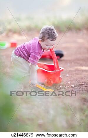 Toddler boy playing on dirt road View Large Photo Image Stock Photo - Toddler boy playing on dirt road. Fotosearch