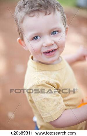 Toddler boy smiling outdoors View Large Photo Image Stock Image - Toddler boy smiling outdoors. Fotosearch
