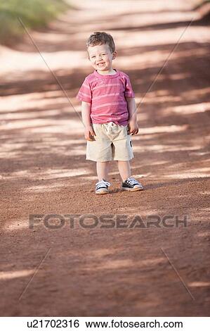 Toddler boy standing on dirt road View Large Photo Image Stock Photograph - Toddler boy standing on dirt road. Fotosearch