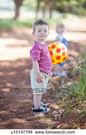 Toddler boy with ball on dirt road View Large Photo Image Picture - Toddler boy with ball on dirt road. Fotosearch