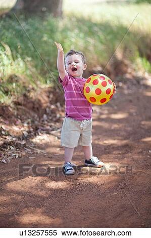 Toddler boy with ball on dirt road View Large Photo Image Stock Photography - Toddler boy with ball on dirt road. Fotosearch