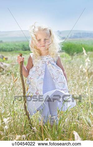 Toddler girl standing in tall grass View Large Photo Image Stock Image - Toddler girl standing in tall grass. Fotosearch