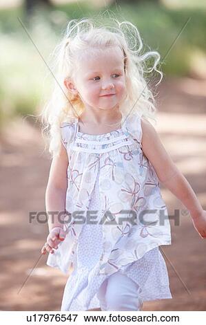 Stock Photo - Toddler girl walking on dirt road. Fotosearch