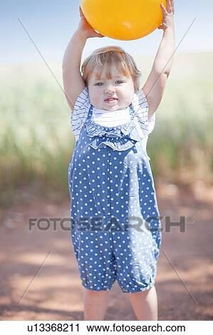 Toddler girl with ball on dirt road View Large Photo Image Stock Image - Toddler girl with ball on dirt road. Fotosearch