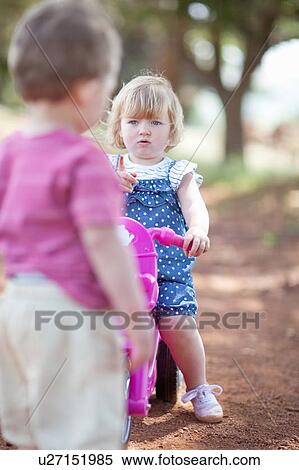 Stock Photography - Toddlers playing on dirt road. Fotosearch