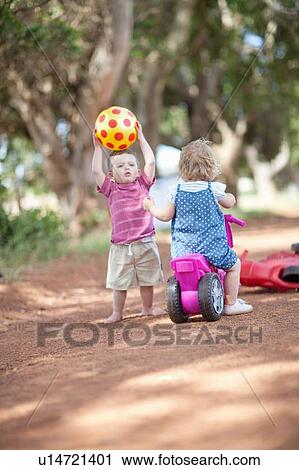 Toddlers playing together on dirt road View Large Photo Image Stock Image - Toddlers playing together on dirt road. Fotosearch