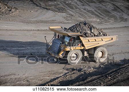Stock Photography - Trucks with coal rocks at surface mine. Fotosearch