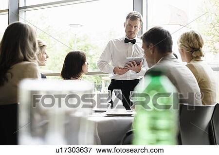 Waiter taking order with tablet computer View Large Photo Image Stock Photo - Waiter taking order with tablet computer. Fotosearch
