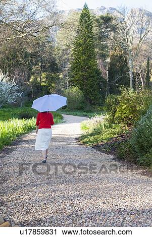 Woman carrying umbrella outdoors View Large Photo Image Stock Image - Woman carrying umbrella outdoors. Fotosearch