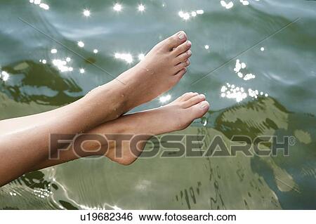 Woman dipping toes into still lake View Large Photo Image Stock Photograph - Woman dipping toes into still lake. Fotosearch
