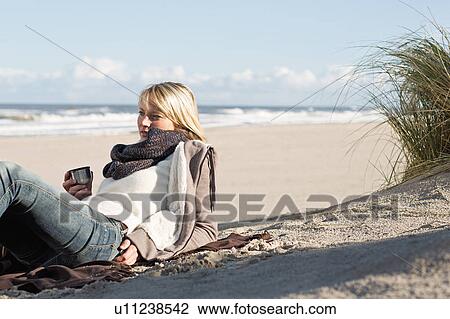 Woman drinking from thermos on beach View Large Photo Image Stock Image - Woman drinking from thermos on beach. Fotosearch