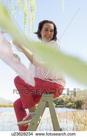 Woman hanging bunting outdoors View Large Photo Image Picture - Woman hanging bunting outdoors. Fotosearch