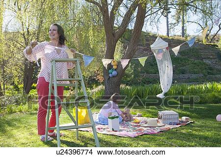 Woman hanging bunting outdoors View Large Photo Image Picture - Woman hanging bunting outdoors. Fotosearch