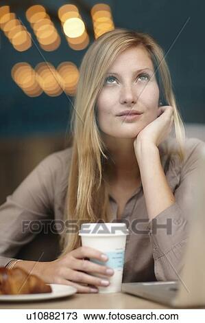 Stock Image - Woman having breakfast in coffee shop. Fotosearch