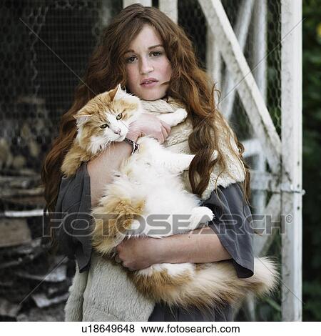 Stock Photo - Woman holding large cat outdoors. Fotosearch