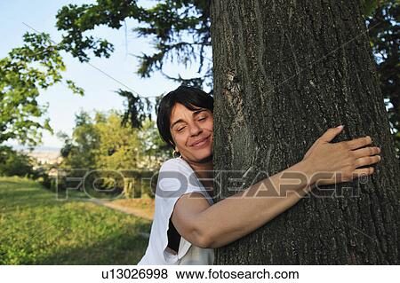 Woman hugging tree in forest View Large Photo Image Stock Photo - Woman hugging tree in forest. Fotosearch