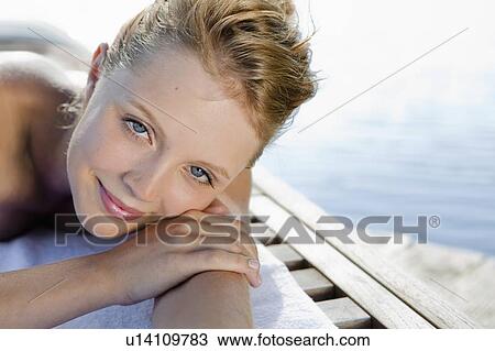 Woman laying on towel outdoors View Large Photo Image Stock Image - Woman laying on towel outdoors. Fotosearch