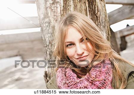 Woman leaning against pole on beach View Large Photo Image Stock Photography - Woman leaning against pole on beach. Fotosearch
