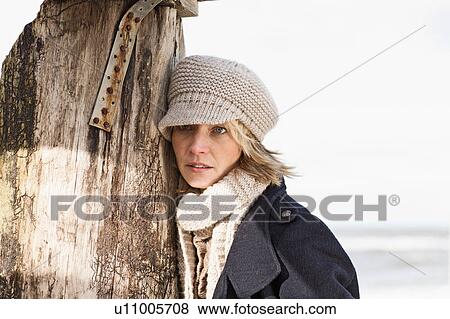 Woman leaning on pole on beach View Large Photo Image Stock Photo - Woman leaning on pole on beach. Fotosearch