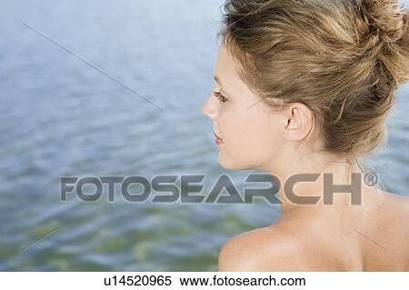 Stock Photography - Woman overlooking still lake. Fotosearch