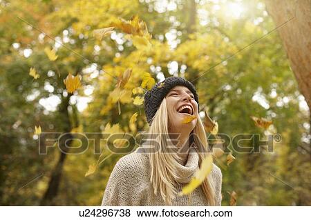 Woman playing in autumn leaves outdoors View Large Photo Image Stock Photo - Woman playing in autumn leaves outdoors. Fotosearch