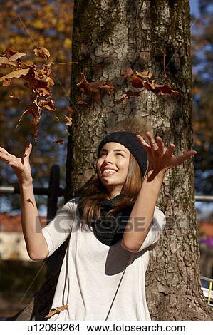 Woman playing in autumn leaves View Large Photo Image Picture - Woman playing in autumn leaves. Fotosearch