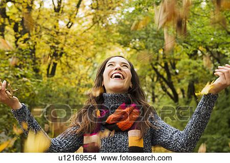 Woman playing in autumn leaves View Large Photo Image Picture - Woman playing in autumn leaves. Fotosearch