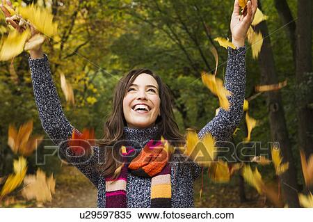 Stock Photography - Woman playing in autumn leaves. Fotosearch