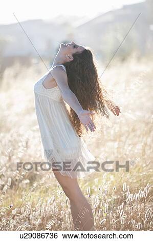 Stock Photograph - Woman playing in tall grass. Fotosearch