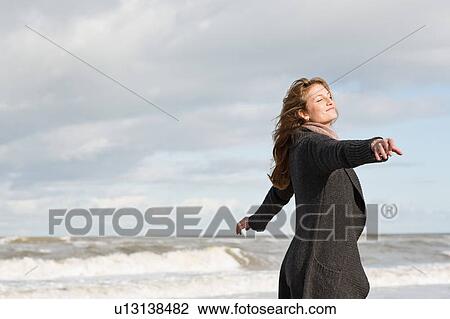 Stock Image - Woman playing on beach. Fotosearch
