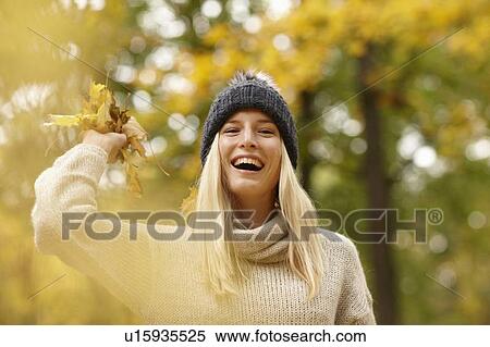 Stock Photography - Woman playing with autumn leaves. Fotosearch