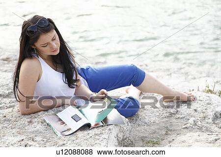 Woman reading magazine on beach View Large Photo Image Stock Photo - Woman reading magazine on beach. Fotosearch