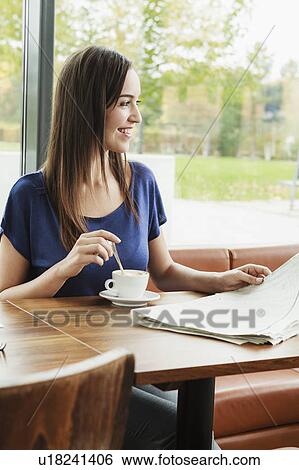 Woman reading newspaper in cafe View Large Photo Image Stock Photograph - Woman reading newspaper in cafe. Fotosearch