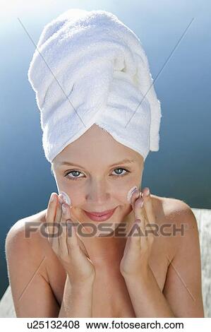 Woman rubbing moisturizer on face View Large Photo Image Stock Photo - Woman rubbing moisturizer on face. Fotosearch