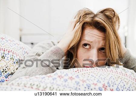 Woman ruffling her hair on bed View Large Photo Image Stock Image - Woman ruffling her hair on bed. Fotosearch