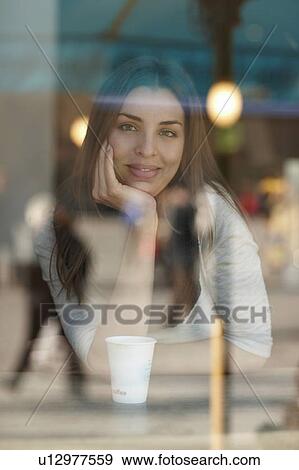 Stock Photo - Woman sitting in coffee shop. Fotosearch