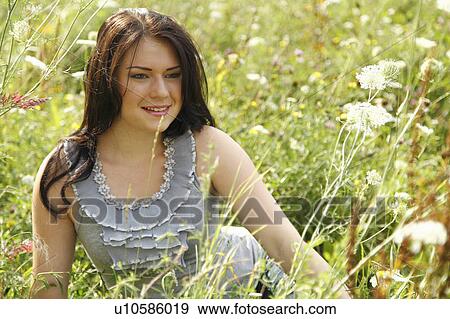 Woman sitting in tall grass View Large Photo Image Stock Photo - Woman sitting in tall grass. Fotosearch