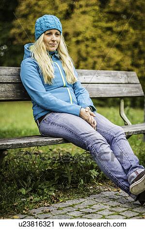Woman sitting on park bench View Large Photo Image Stock Image - Woman sitting on park bench. Fotosearch