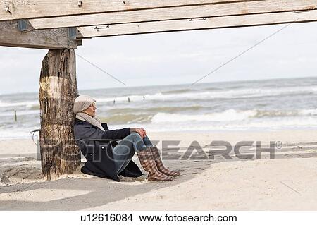 Woman sitting under abandoned pier View Large Photo Image Picture - Woman sitting under abandoned pier. Fotosearch