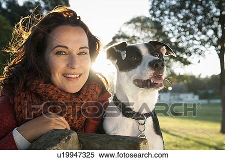 Woman sitting with dog on park bench View Large Photo Image Stock Photography - Woman sitting with dog on park bench. Fotosearch