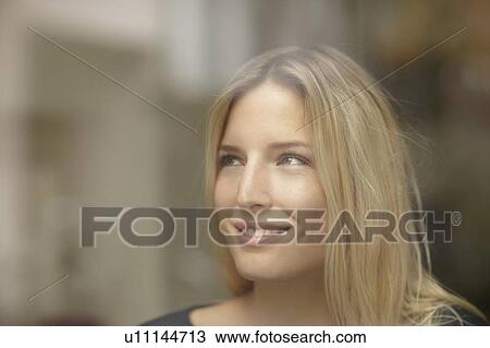 Stock Image - Woman smiling behind window. Fotosearch