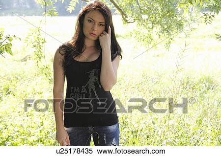 Stock Photography - Woman standing in tall grass. Fotosearch