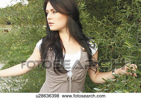 Woman standing in tall plants View Large Photo Image Stock Photo - Woman standing in tall plants. Fotosearch
